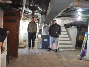 HVAC technicians standing in front of a new installed furnace won during Vailes' Scary Furnace Giveaway Contest.