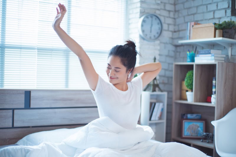 Woman in bed and waking up in the morning. She felt very refreshed.