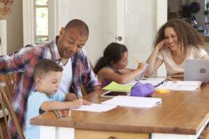 What Size Heat Pump Do I Need? Photo of a family working on homework with the children in their kitchen on the table.